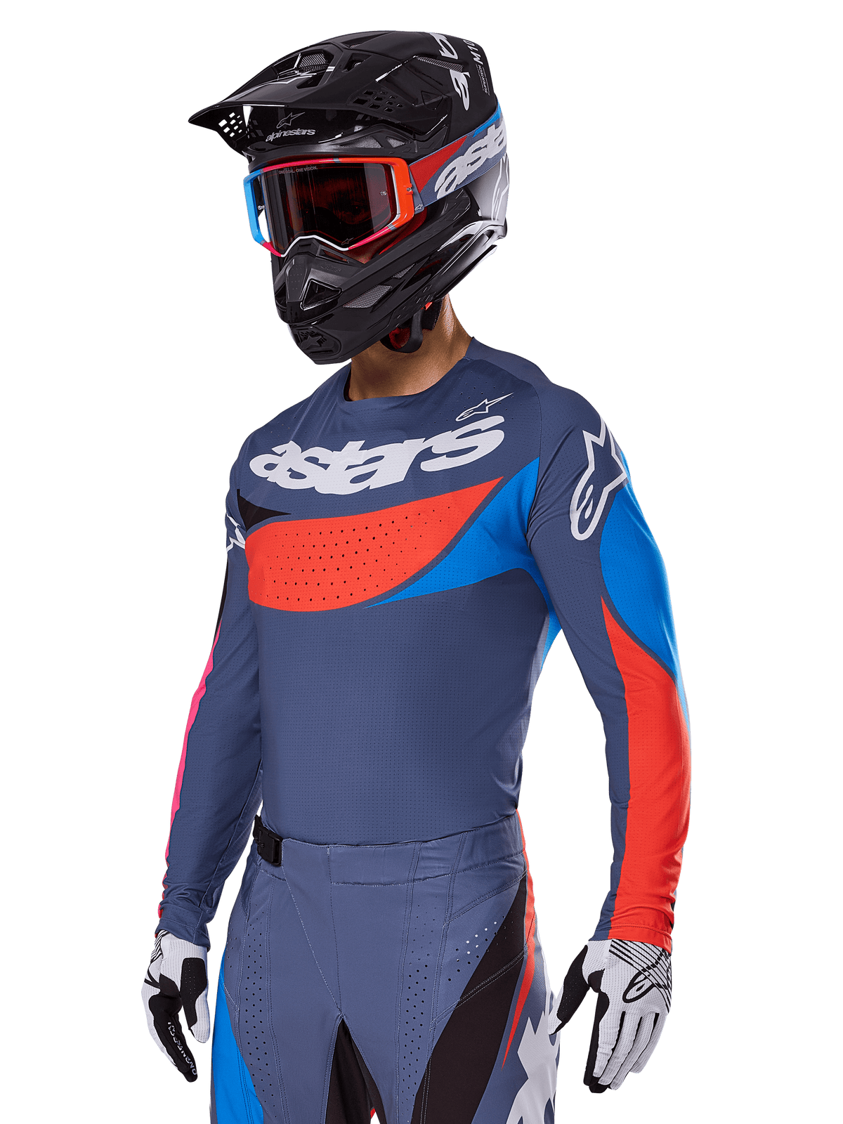 Alpinestars 2025 Techstar Dreem Gear Set, Motocross-Fahrer in schiefergrauem Jersey und Hose mit markanten roten und blauen Grafiken, „astars“-Branding auf der Brust, schwarzer Helm, Goggles mit rotem Rahmen und weiße Rennhandschuhe