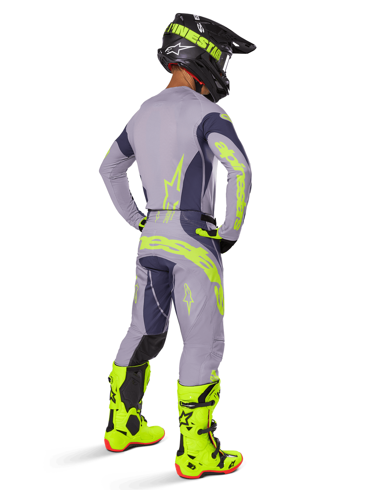 Motocross-Fahrer in der Rückansicht im Alpinestars 2025 Techstar Dreem Gear Set, Grau und Dunkelgrau mit neongelbem Branding, passendes Trikot und Hose, schwarzer Helm mit gelben Akzenten und leuchtend neongelbe Stiefel, professionell abgestimmtes Motocross-Outfit.