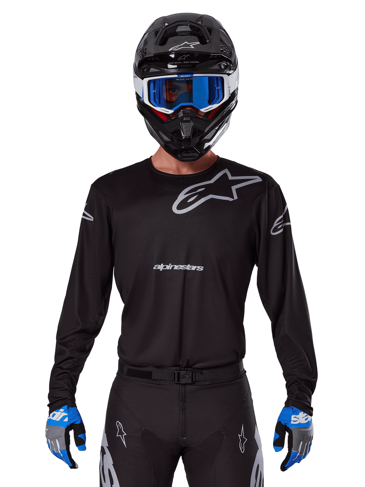 Alpinestars 2025 Racer Graphite Trikot, Motocross-Rennausrüstung, Schwarz mit grauen Logos, getragen mit passendem schwarzem Helm, blauer Brille und blau-grauen Handschuhen, körpernahes Performance-Design mit Branding auf Brust und Armen