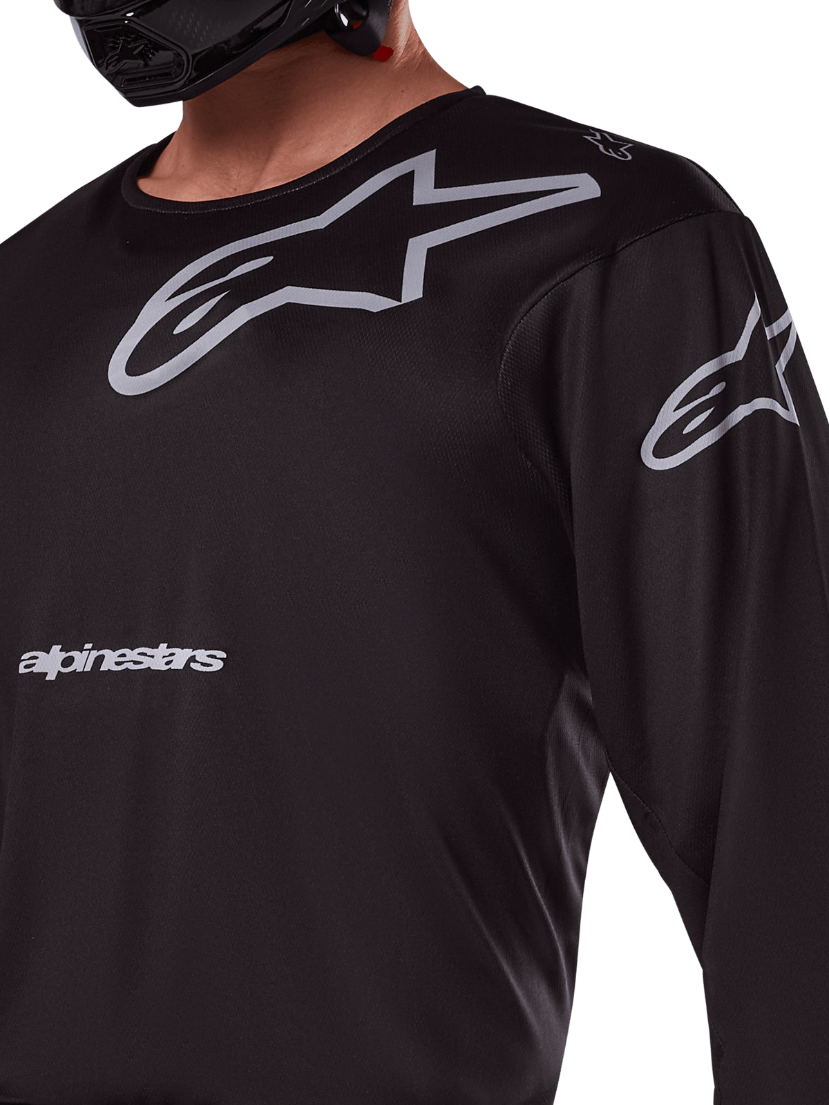 Alpinestars 2025 Racer Graphite Trikot, Schwarz und Grau, Nahaufnahme eines Fahrers im Motocross-Trikot, mit grauem Alpinestars-Branding und A-Star-Logos, technisches Poly-Gewebe für Offroad-Fahrten