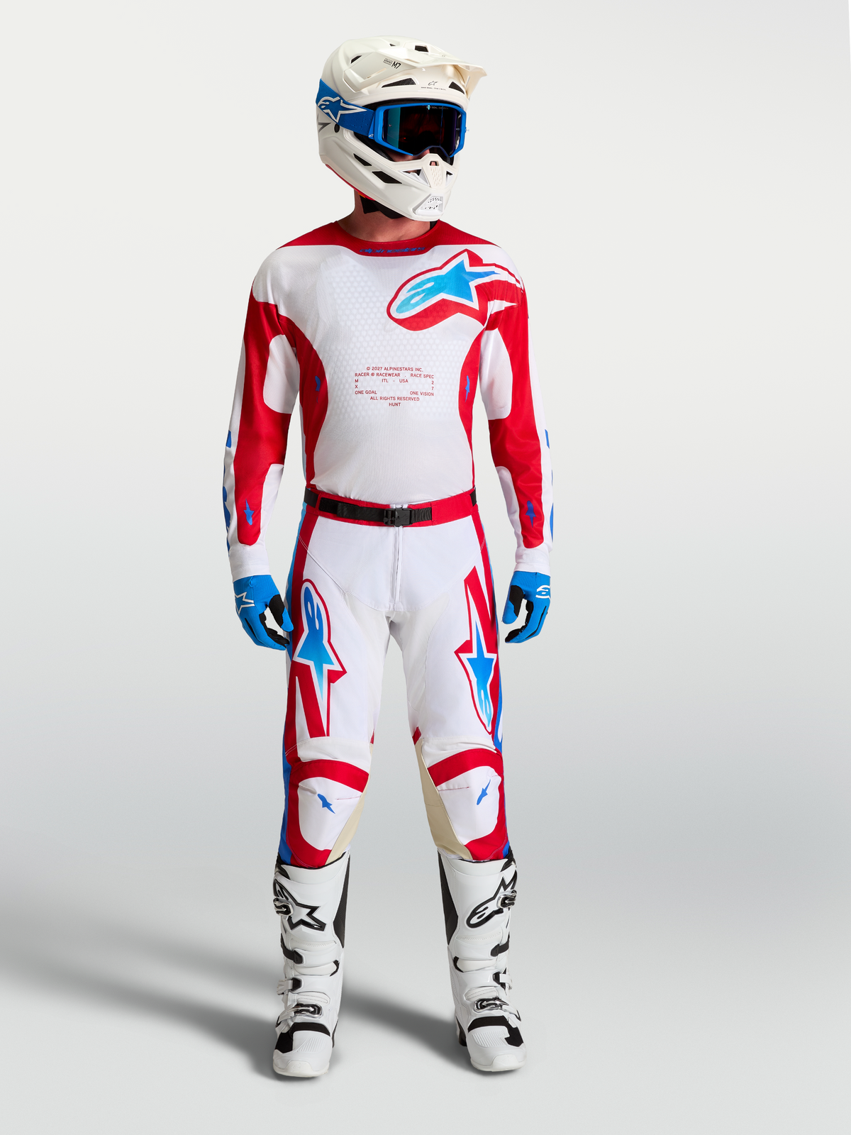 Alpinestars Racer Hunt Jersey, wit en rood heren motorcrossset met blauwe accenten, bijpassende broek en motorlaarzen.