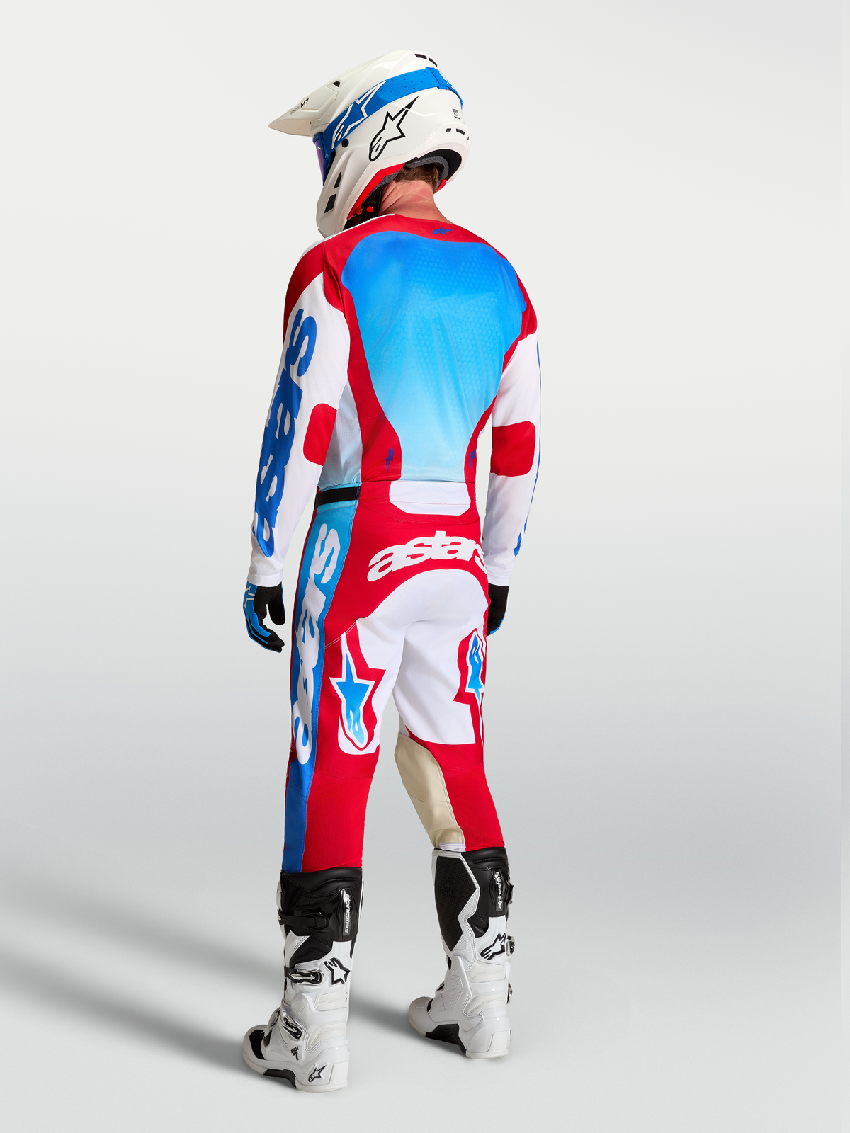 Alpinestars Pantalons Racer Hunt et Gear Set, tenue de motocross homme, rouge, blanc et bleu, vue de dos sur pilote.