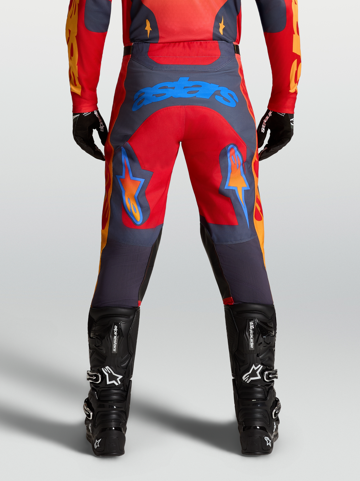 Alpinestars Pantalon Racer Hunt, pantalon de motocross pour homme, rouge et gris, avec logo Astars bleu sur l'assise, jambe pré-courbée et renforts aux genoux