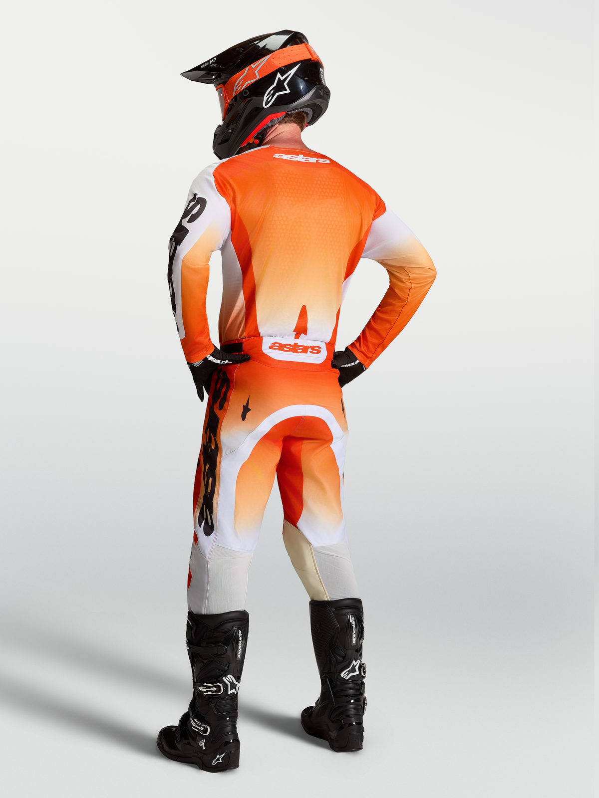 Alpinestars pantalon Racer Amber et ensemble Racer Amber, tenue de motocross orange et blanche pour homme, vue de dos sur mannequin, coupe racing performante.