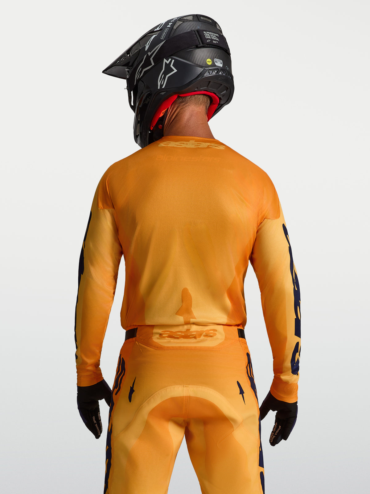 Maillot Racer Amber Alpinestars, maillot de motocross homme, orange et doré, panneaux en maille, vue de dos sur mannequin