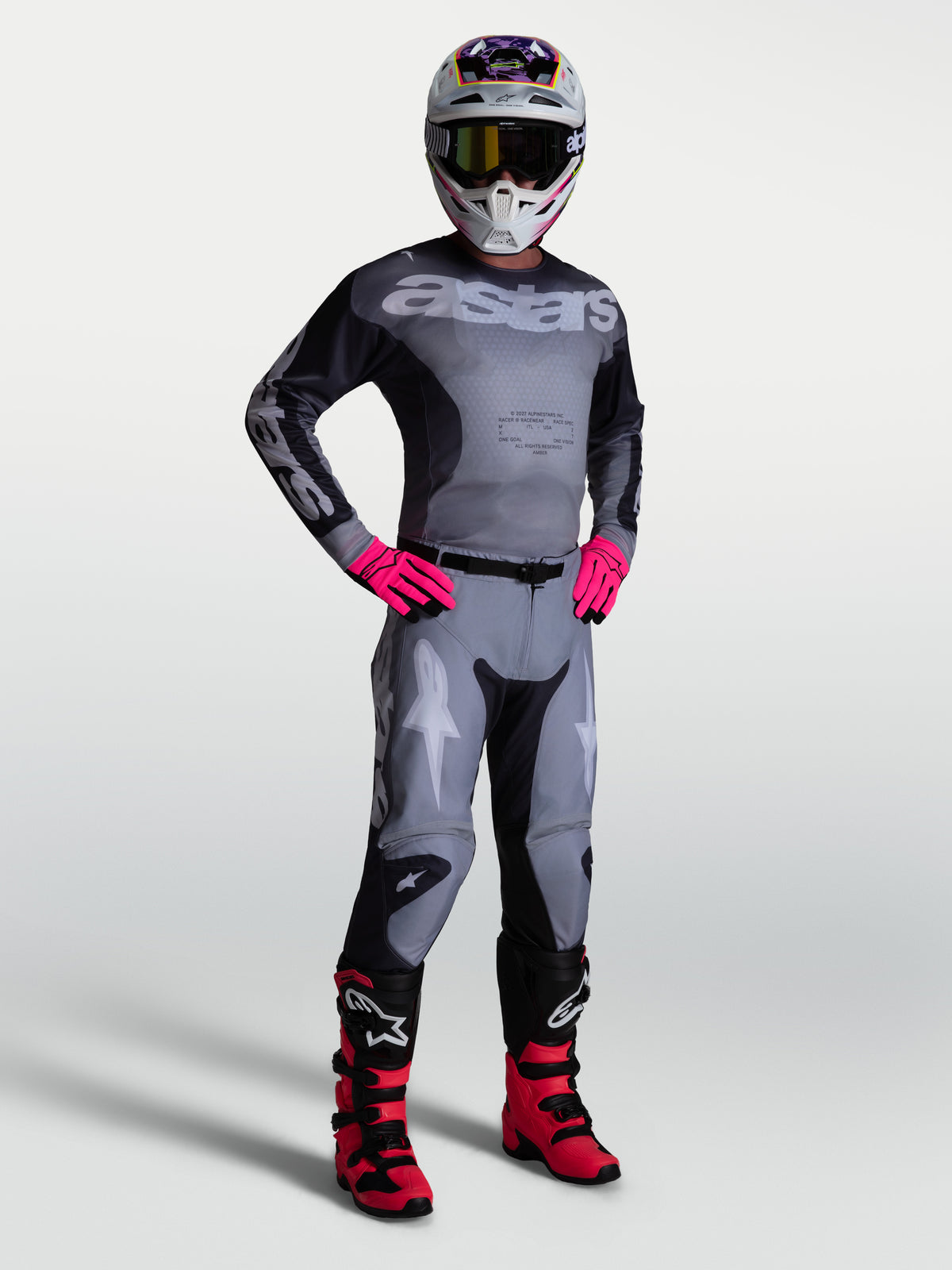 Alpinestars 2027 Racer Amber jersey en gear set, grijze en roze heren motocrossuitrusting met een atletische pasvorm.