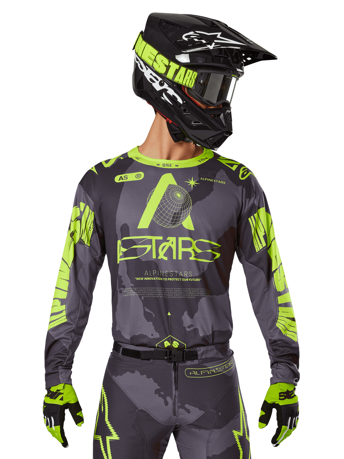 Maillot Alpinestars 2025 Racer Hollow, maillot de motocross, camouflage sombre et jaune fluo, porté avec pantalon assorti, casque noir et jaune avec masque et gants noirs, avec logo Alpinestars et motif camouflage