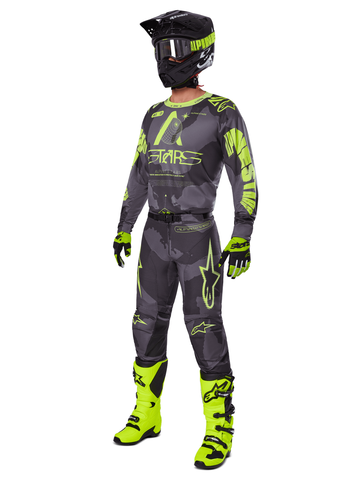 Pilote de motocross portant l'ensemble d'équipement Alpinestars Racer Hollow 2025, maillot et pantalon Dark Camo et jaune fluo, casque noir et jaune fluo, gants assortis et bottes jaune fluo éclatant, tenue coordonnée pour la course tout-terrain