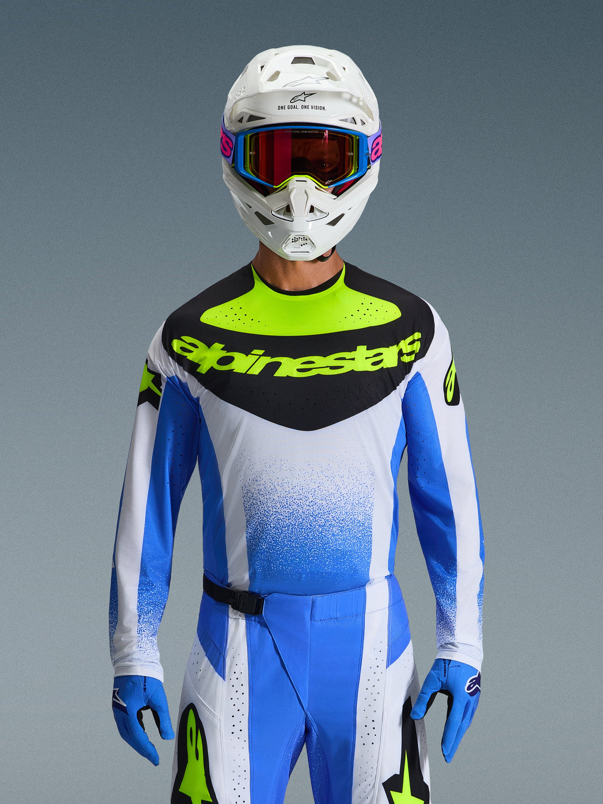 Alpinestars 2026 Techstar Knif Ausrüstungsset, Motocross-Fahrer in blau-weiß-neongelber Rennausrüstung, Trikot mit schwarzem Brustbereich und neongelbem Logo, weißer Helm mit mehrfarbiger Brille, passende blaue Handschuhe und Hose, hochleistungsfähiges sportliches Rennoutfit für den Offroad-Wettbewerb