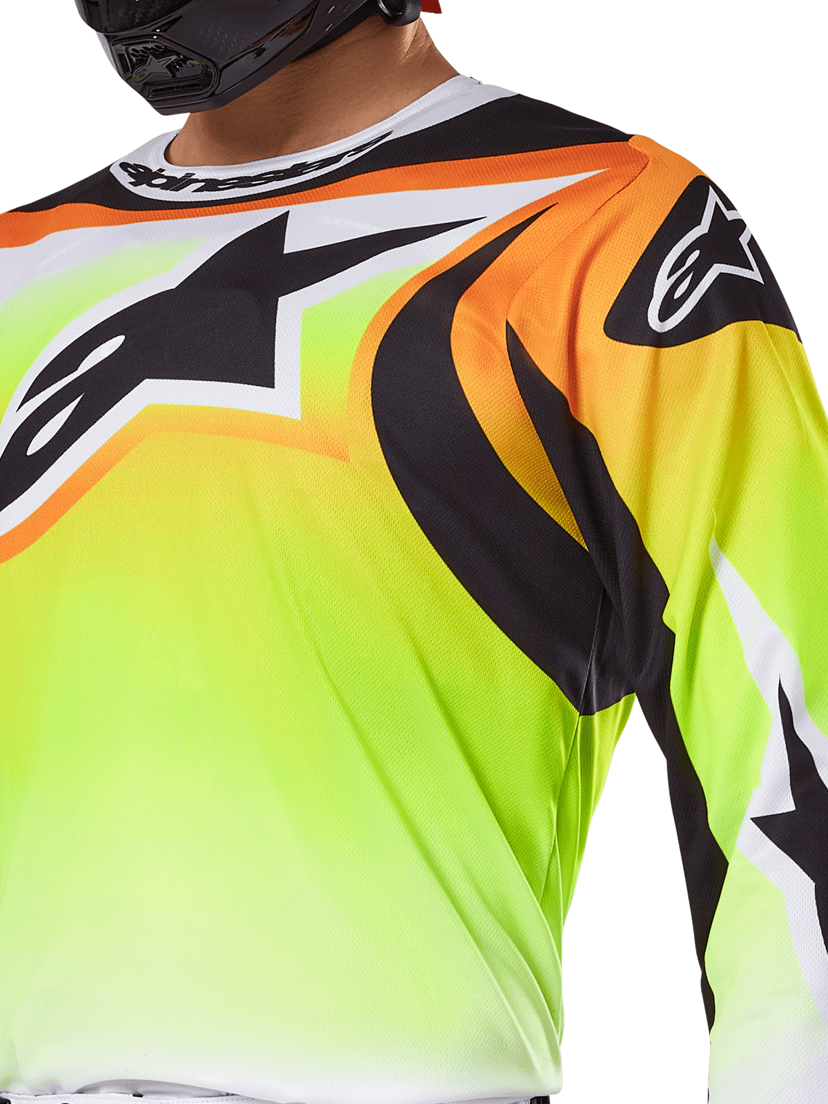 Alpinestars 2025 Fluid Wurx Trikot, Motocross-Trikot, Fluorgelb mit schwarzen und orangen Grafiken, mit einem großen schwarzen Alpinestars-Logo auf der Brust und an der Schulter, getragen von einem Fahrer mit schwarzem Helm.
