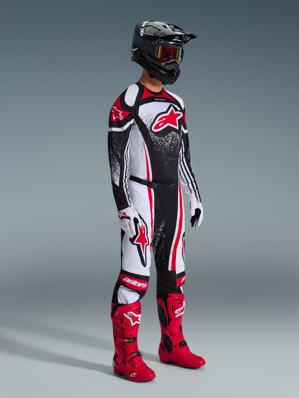 Motocross-Fahrer im 2026 Techstar Nomur Trikot, schwarz-weiß-rote Rennbekleidung, passende Hose mit roten Akzenten, schwarzer Helm, leuchtend rote Stiefel, weiß-schwarze Handschuhe, professionelle Motocross-Ausrüstung für Offroad-Wettkämpfe.