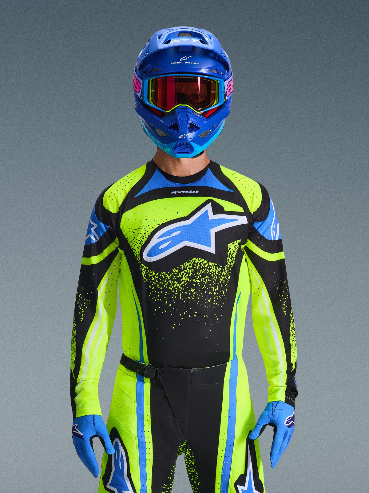 Ensemble d'équipement Alpinestars Techstar Nomur 2026, pilote de motocross portant un maillot noir, jaune fluo et bleu avec pantalon et gants assortis, casque bleu avec lunettes réfléchissantes, tenue de course professionnelle pour la compétition tout-terrain, vue de face