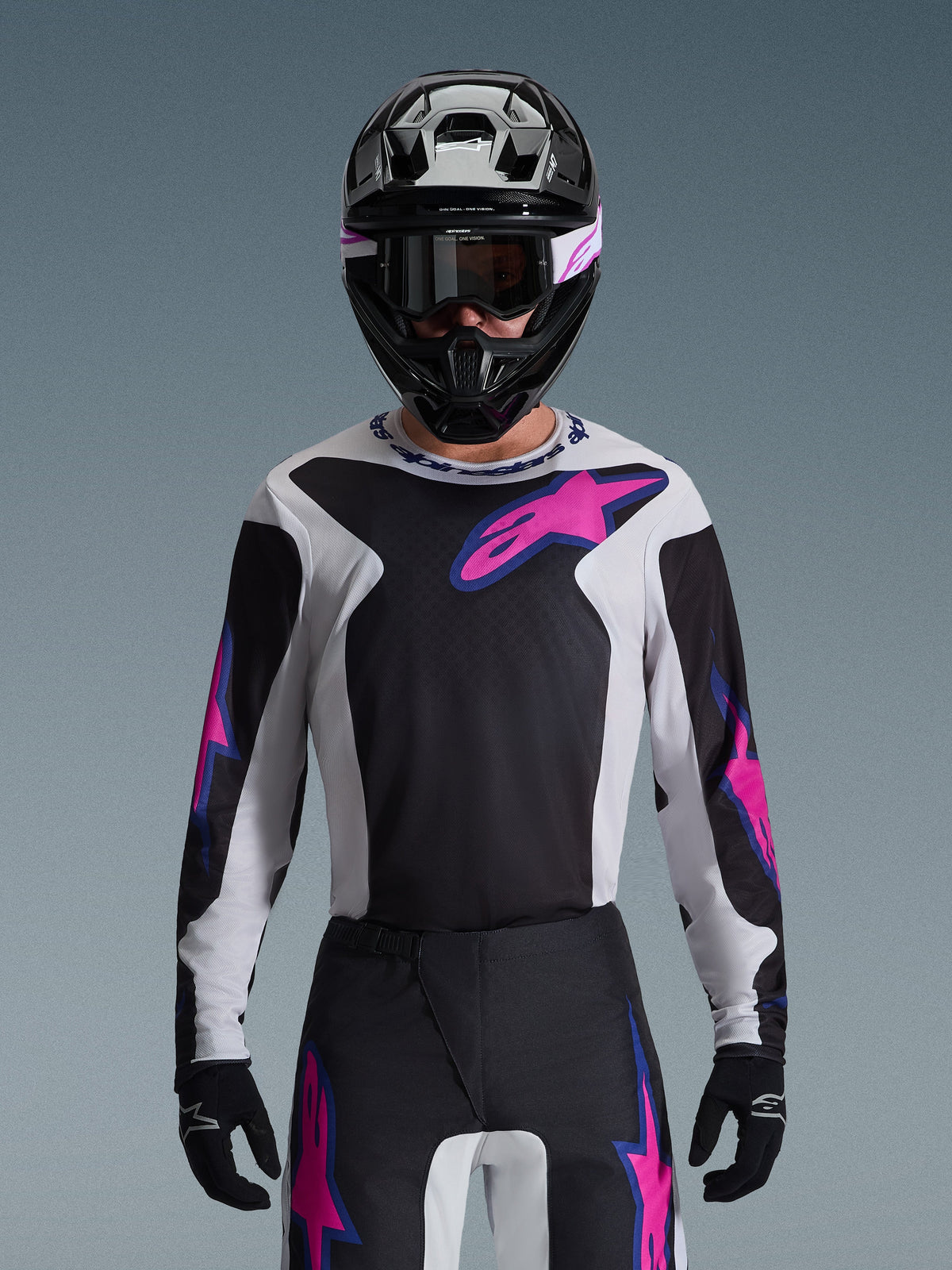 Alpinestars 2026 Fluid Grid Gear Set, pilote de motocross portant un maillot noir, blanc et rose avec un pantalon assorti, casque noir avec accents roses et blancs, tenue de course professionnelle coordonnée pour la performance tout-terrain