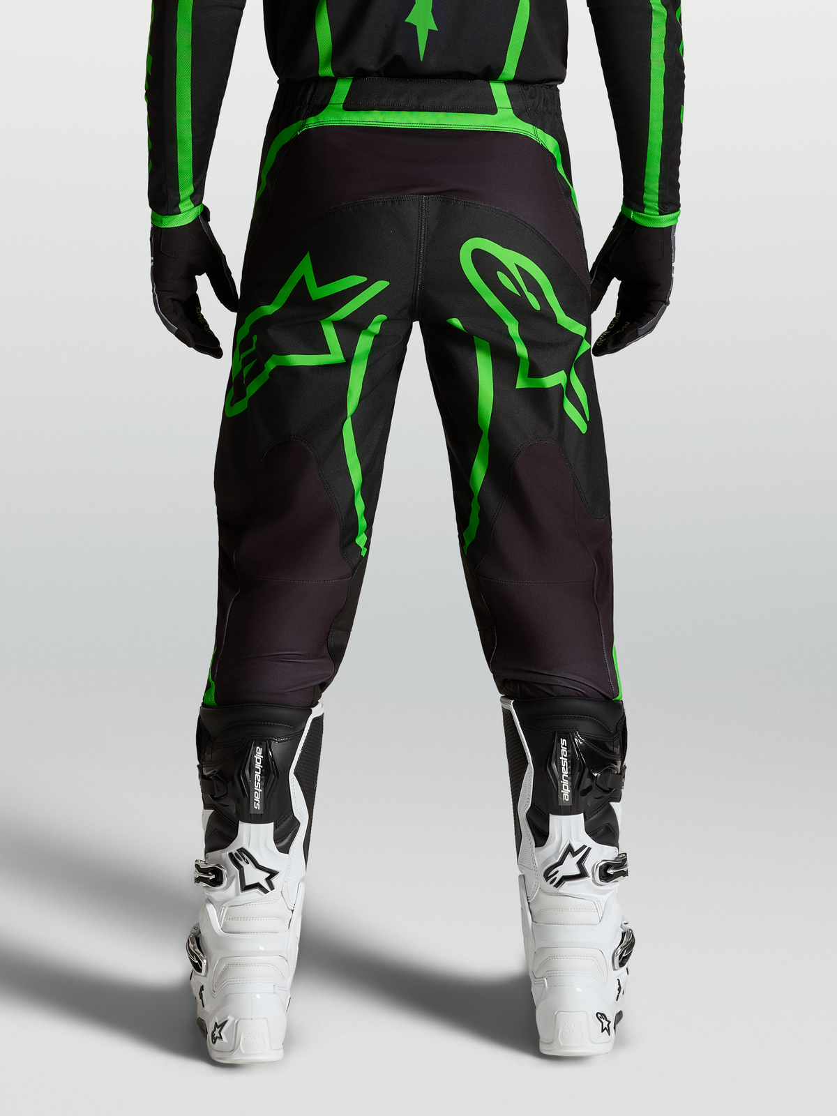 Pantalons Alpinestars Fluid Apex V2, pantalon de motocross pour homme, noir et vert fluo avec graphismes d'étoiles larges, vue de dos sur mannequin