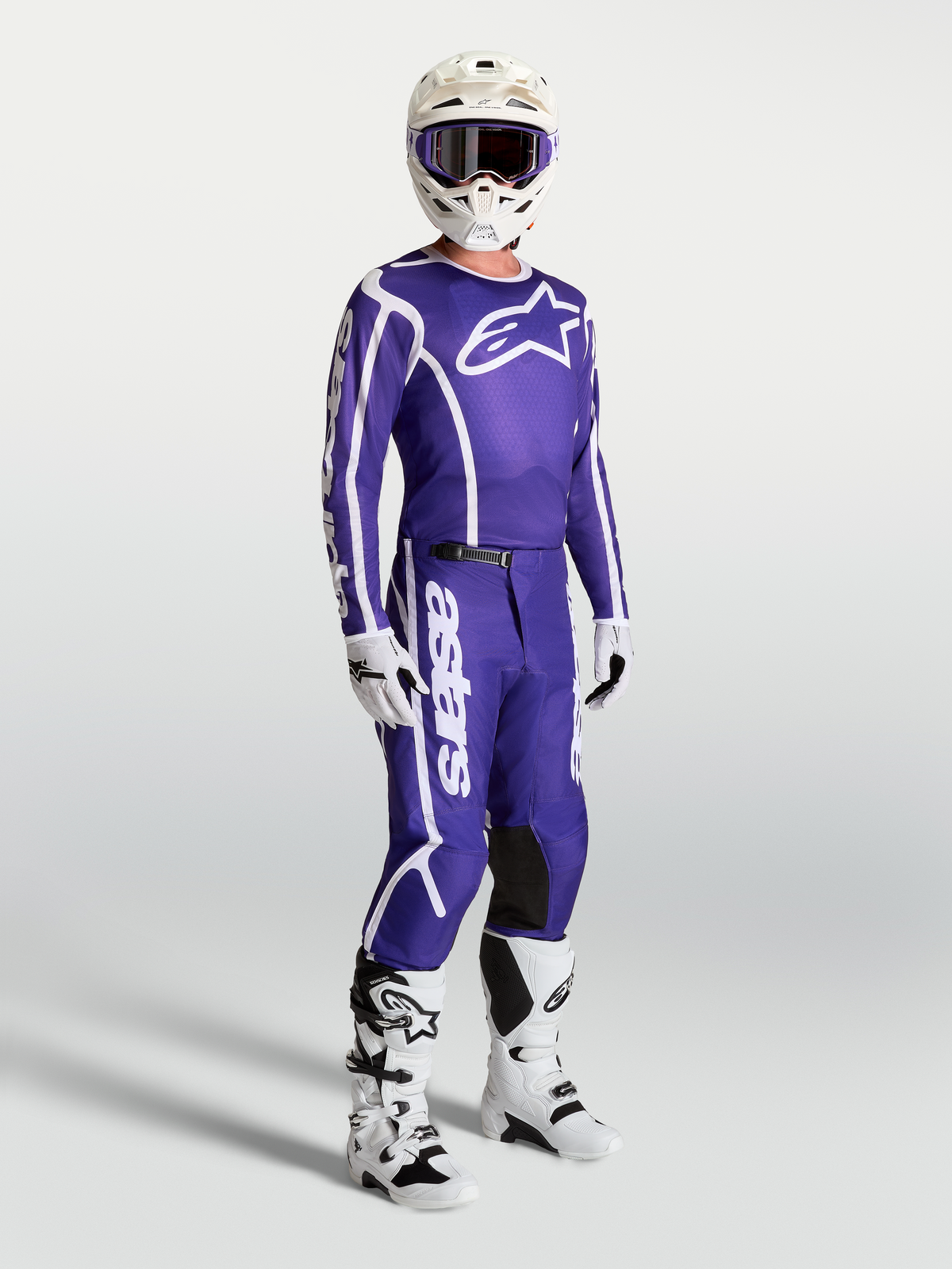 Maillot Alpinestars Fluid Apex V2 et pantalon de motocross pour homme, bleu foncé et blanc, portés avec bottes et casque