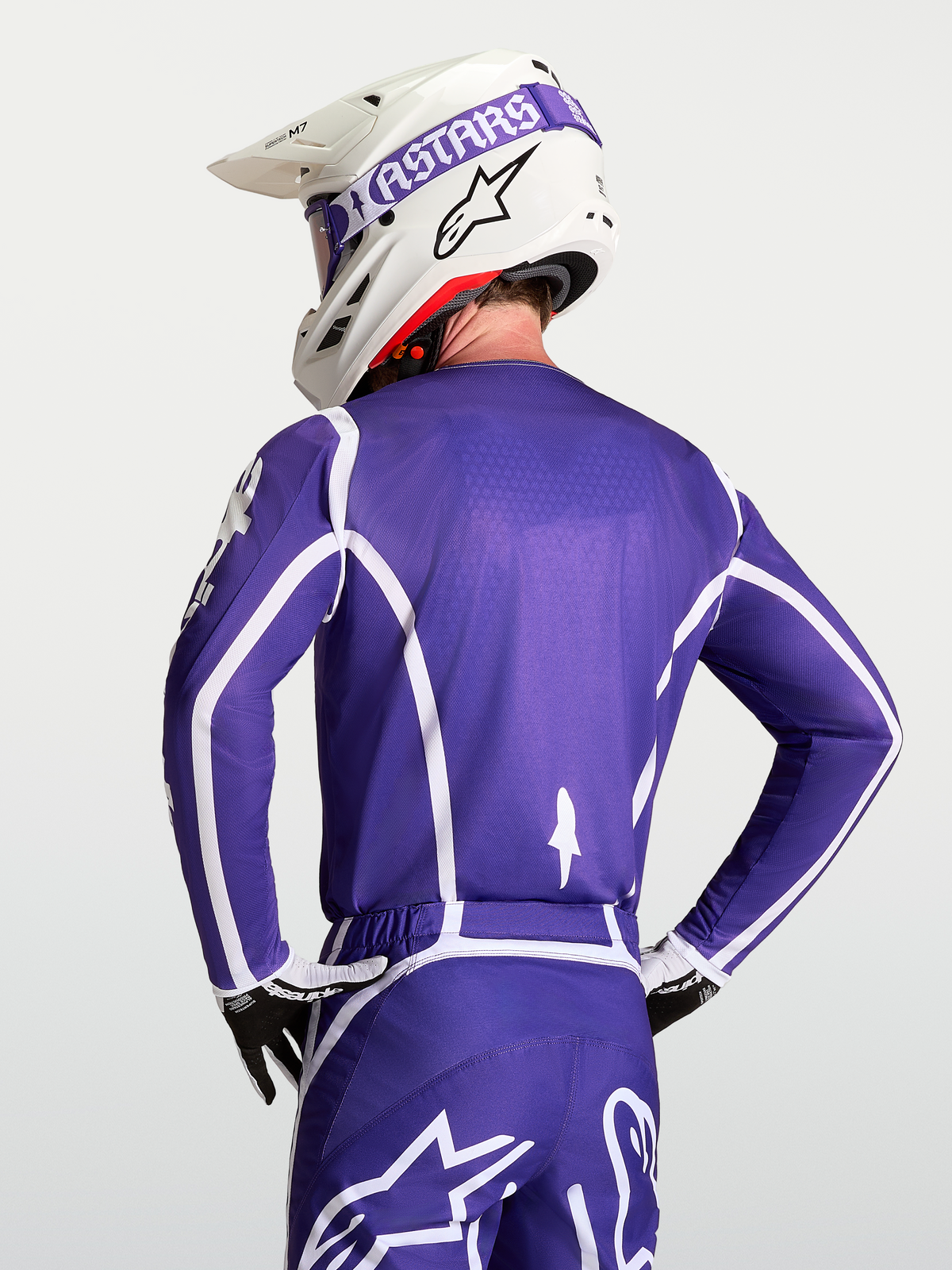 Alpinestars Maillot Fluid Apex V2, maillot de motocross pour homme bleu foncé et blanc, vue de dos sur mannequin avec casque, construction respirante en poly-tissu évacuant l'humidité