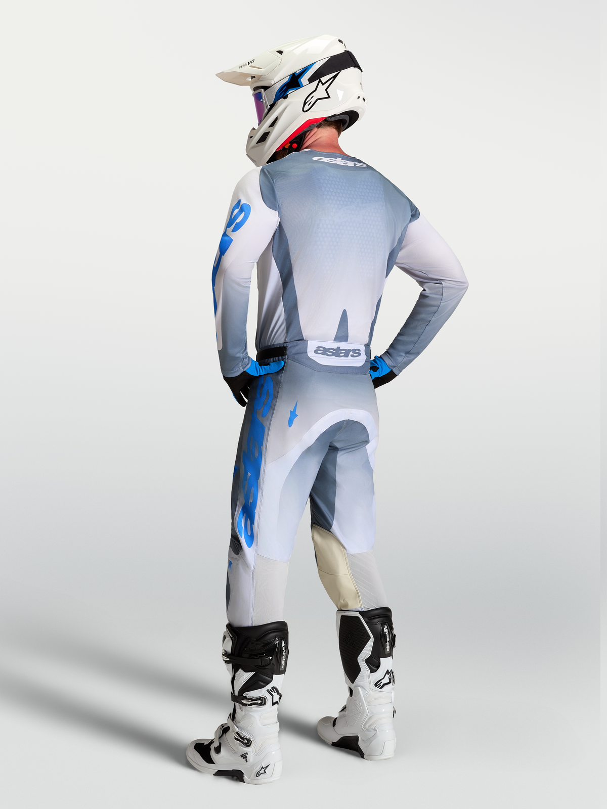 Alpinestars pantalon Racer Amber et ensemble de motocross 2027 pour homme, gris et bleus, vue de dos sur un pilote.