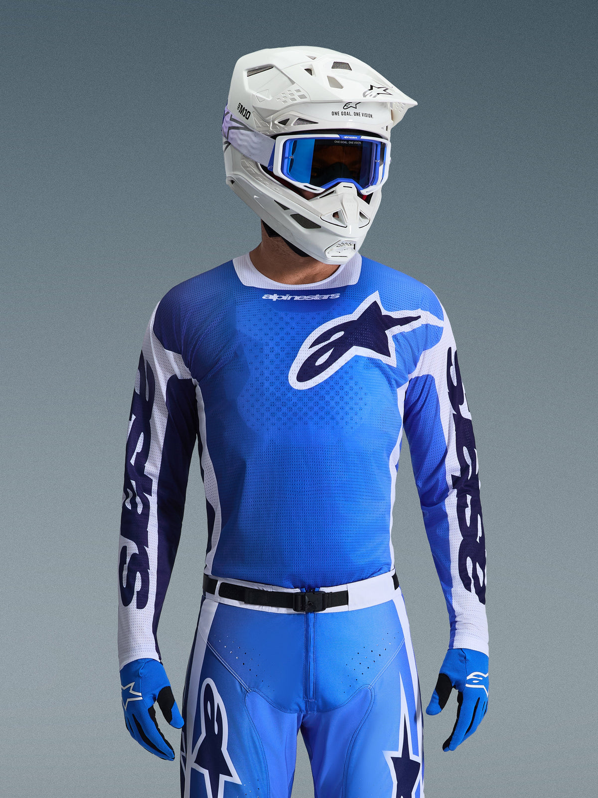 Alpinestars 2026 Racer Air Portl Jersey in Ucla Blue en wit, motocross jersey met een ademende mesh-constructie en opvallend sterlogo, gedragen door een rijder met bijpassende broek, witte helm en blauwe bril voor een gecoördineerde off-road raceset.