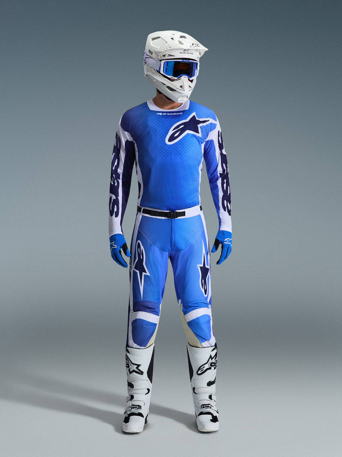 Motorcrossrijder in Alpinestars 2026 Racer Air Portl Jersey in Ucla Blue White, gecombineerd met een bijpassende blauwe motorcrossbroek, een witte helm met blauwe crossbril, blauwe handschoenen en witte laarzen, complete professionele uitrusting voor off-road racen