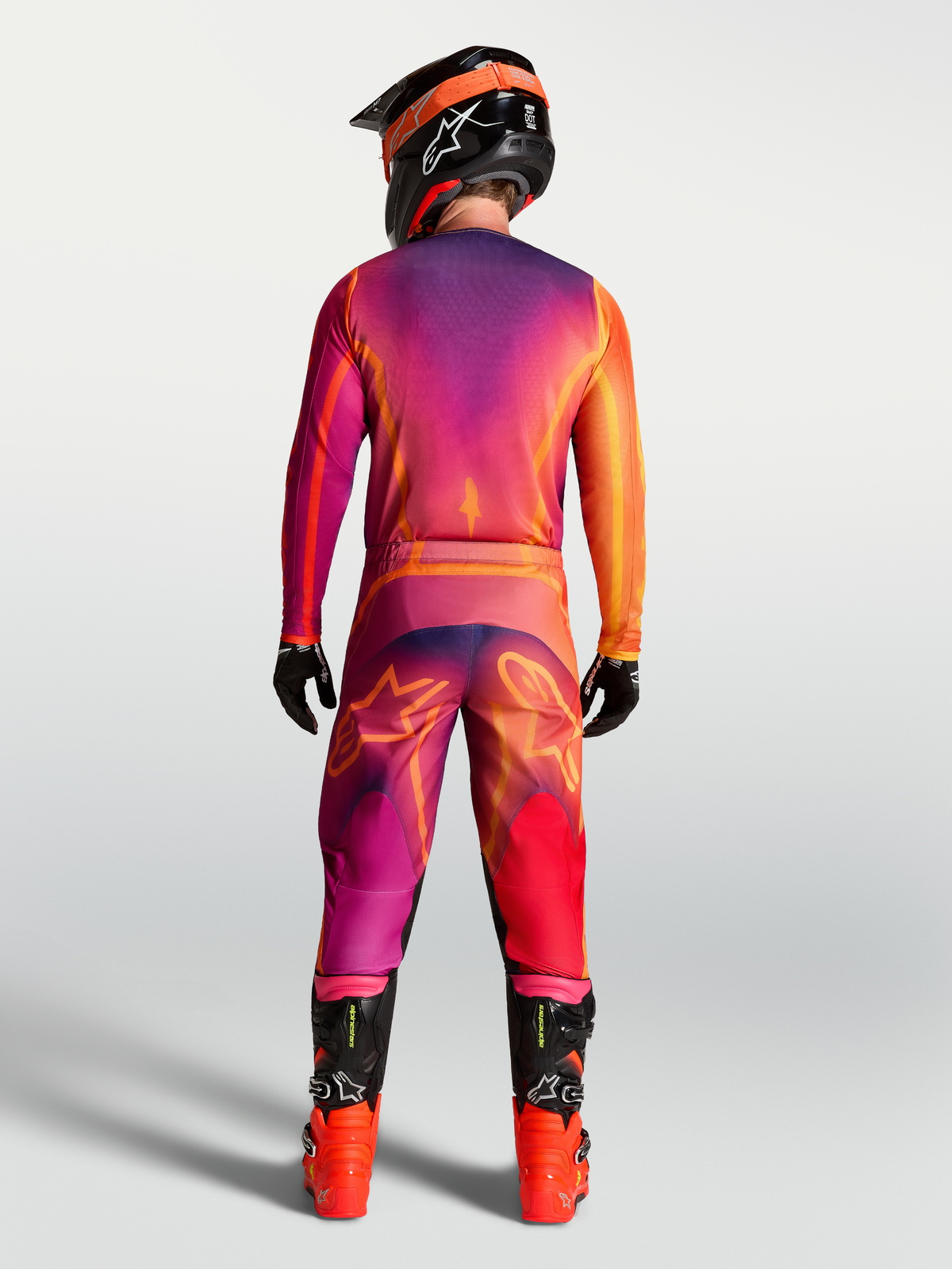 Alpinestars Fluid Kepler Hose, Motocross-Hose, Lila und Orange, Rückansicht am Model mit Trikot und Stiefeln.
