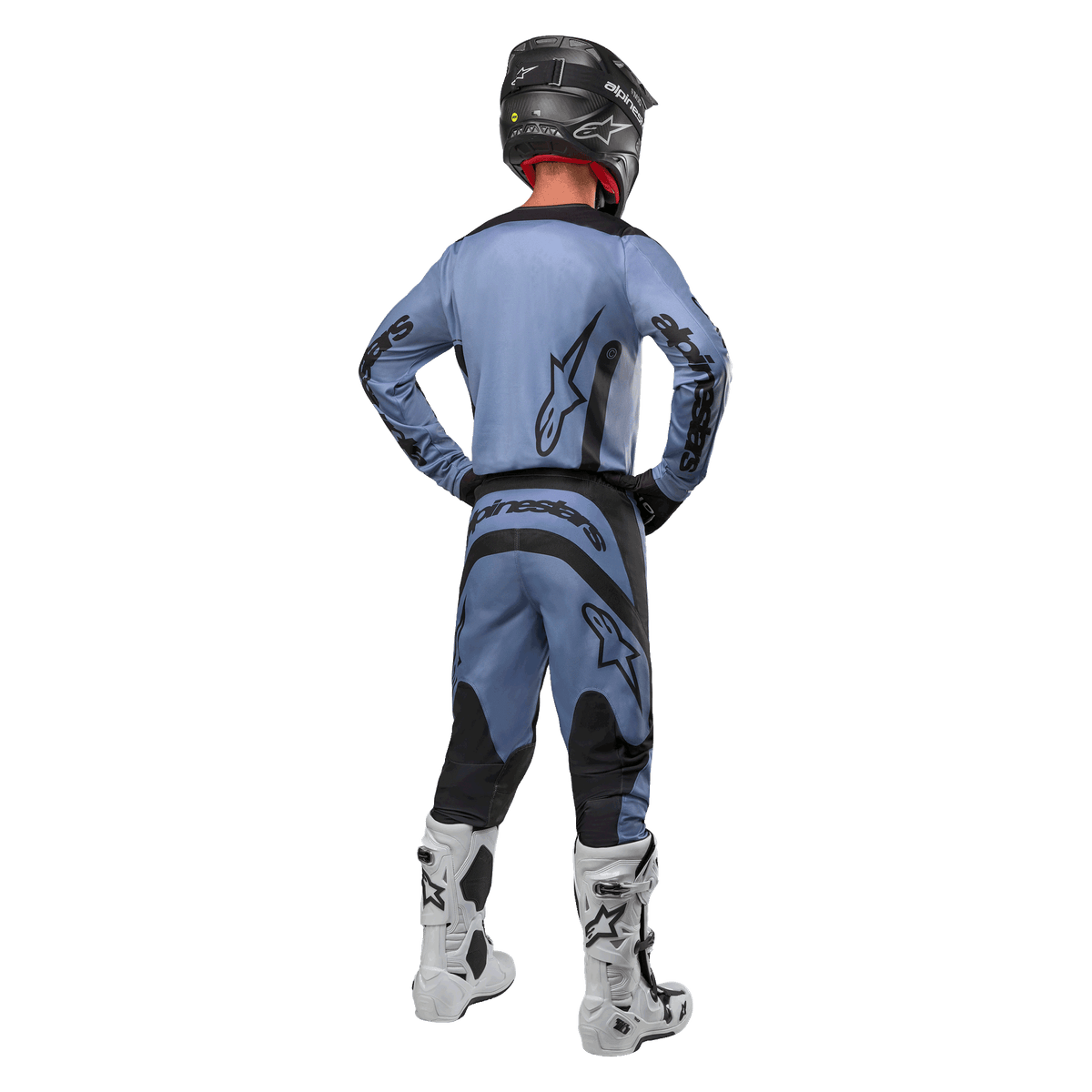 Pilote de motocross de dos portant le maillot Alpinestars 2024 Fluid Lurv et le pantalon assorti bleu clair et noir, avec logos noirs sur le dos et les manches, associé à un casque noir et des bottes blanches.