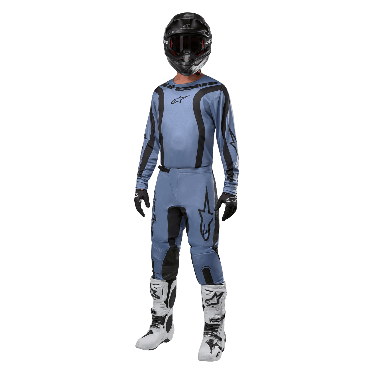 Pilote de motocross portant un équipement de course complet, maillot Alpinestars Fluid Lurv 2024 bleu clair et noir, pantalon bleu clair assorti avec empiècements noirs, bottes blanches et noires, gants noirs et casque noir avec lunettes, tenue coordonnée pour la course tout-terrain