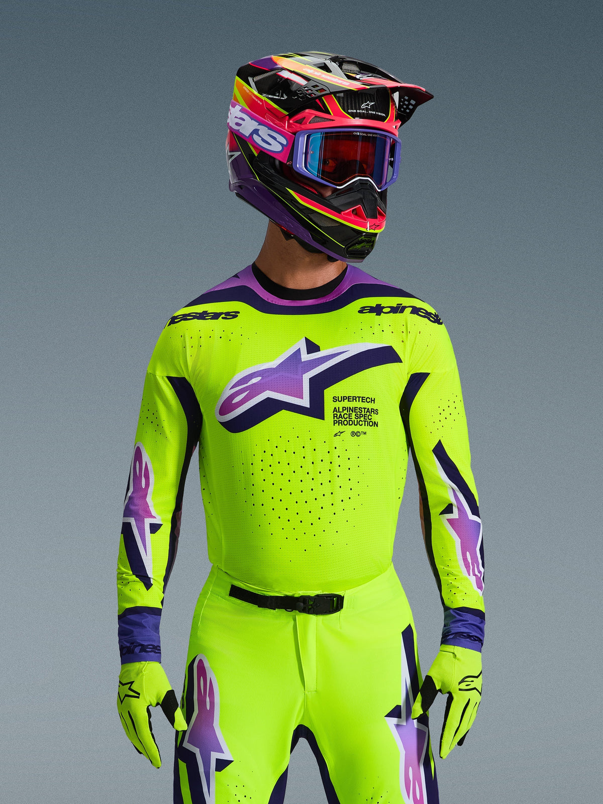 Maillot Alpinestars Supertech Vista 2026, maillot de motocross, jaune fluo éclatant avec accents violets et noirs, porté avec casque, lunettes et gants de motocross assortis, coupe athlétique de niveau pro pour la course tout-terrain
