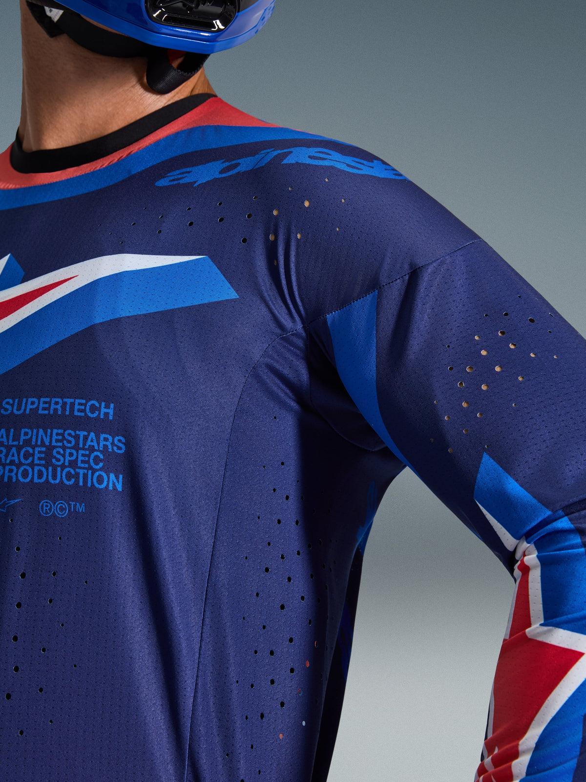 Alpinestars 2026 Supertech Vista Jersey, motocross jersey, Dark Navy met Hot Coral en Cobalt accenten, close-up met lasergesneden ventilatieperforaties en ademende mesh-textuur, voorzien van 'Supertech Race Spec' branding, professionele race-uitrusting