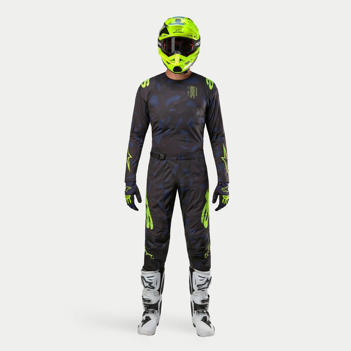 Motocross rider wearing complete racing gear, 2024 Techstar Rantera Jersey in Black Navy and Yellow Fluo, matching abstract print pants, bright fluo yellow helmet, white and black boots, coordinated outfit for off-road racing