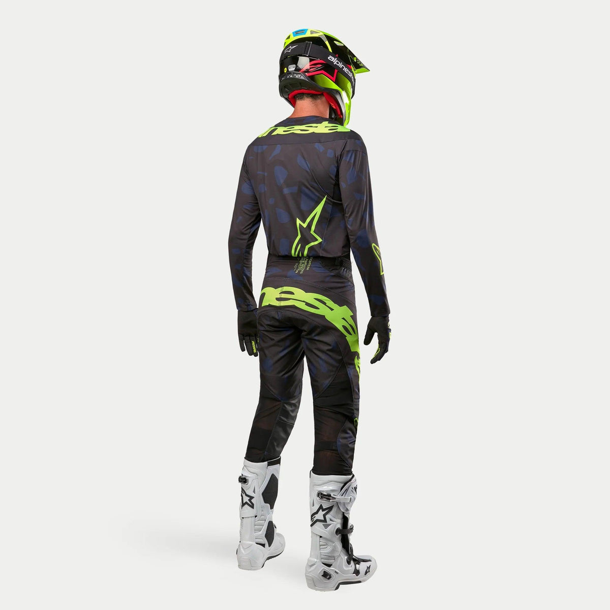 Alpinestars 2024 Techstar Rantera Jersey, Motocross Jersey, Black Navy Yellow Fluo, worn with matching pants, white and black boots, and a fluo yellow helmet, viewed from the back in complete off-road racing gear