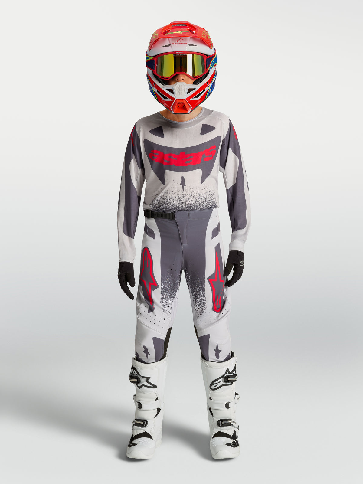 Maillot et ensemble Supertech Swan Junior Alpinestars 2027, tenue de motocross grise et blanche aux accents rouges.