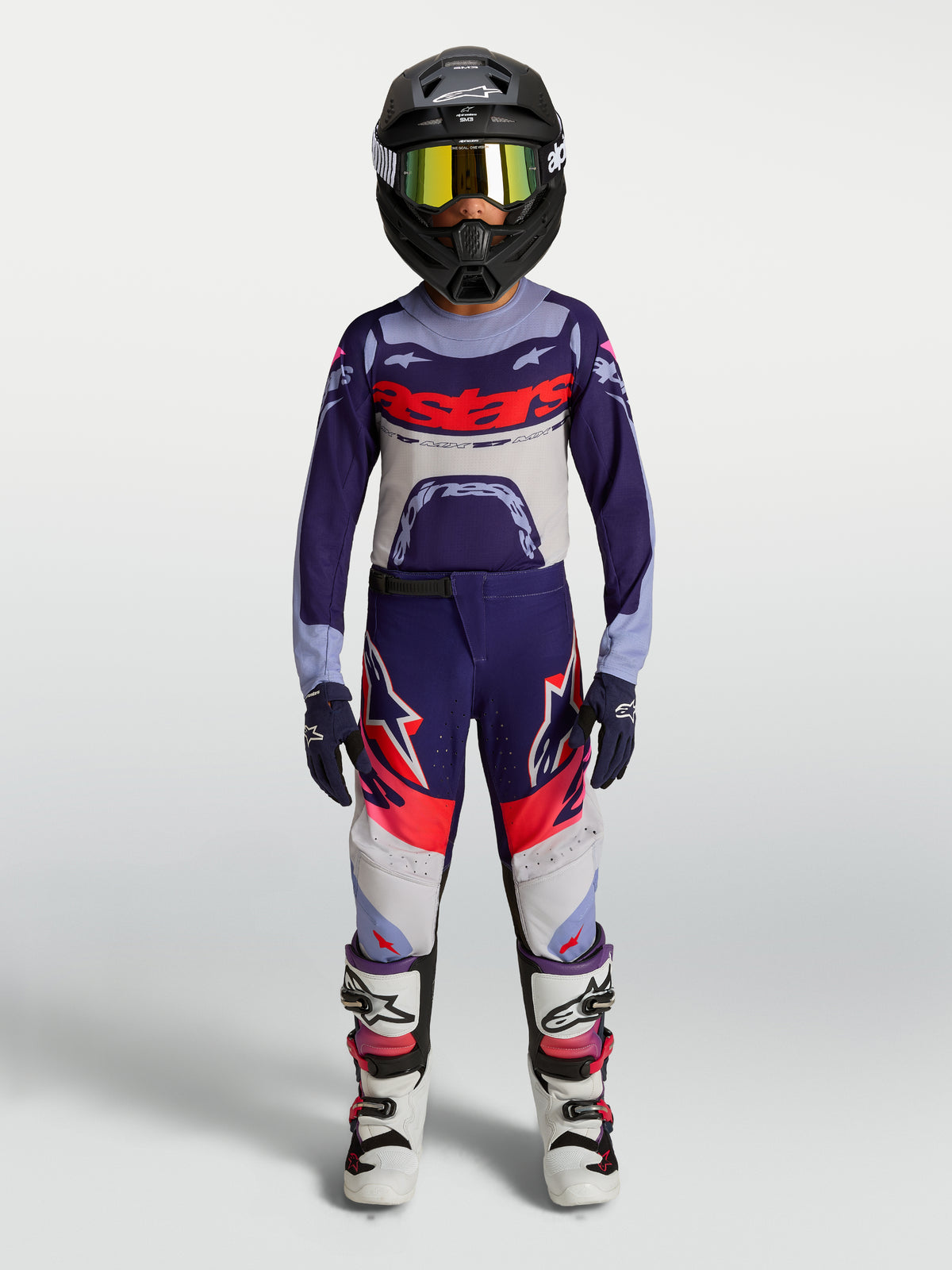 Ensemble Alpinestars Supertech Dyna Junior 2027, tenue de motocross violette et blanche avec casque et bottes.
