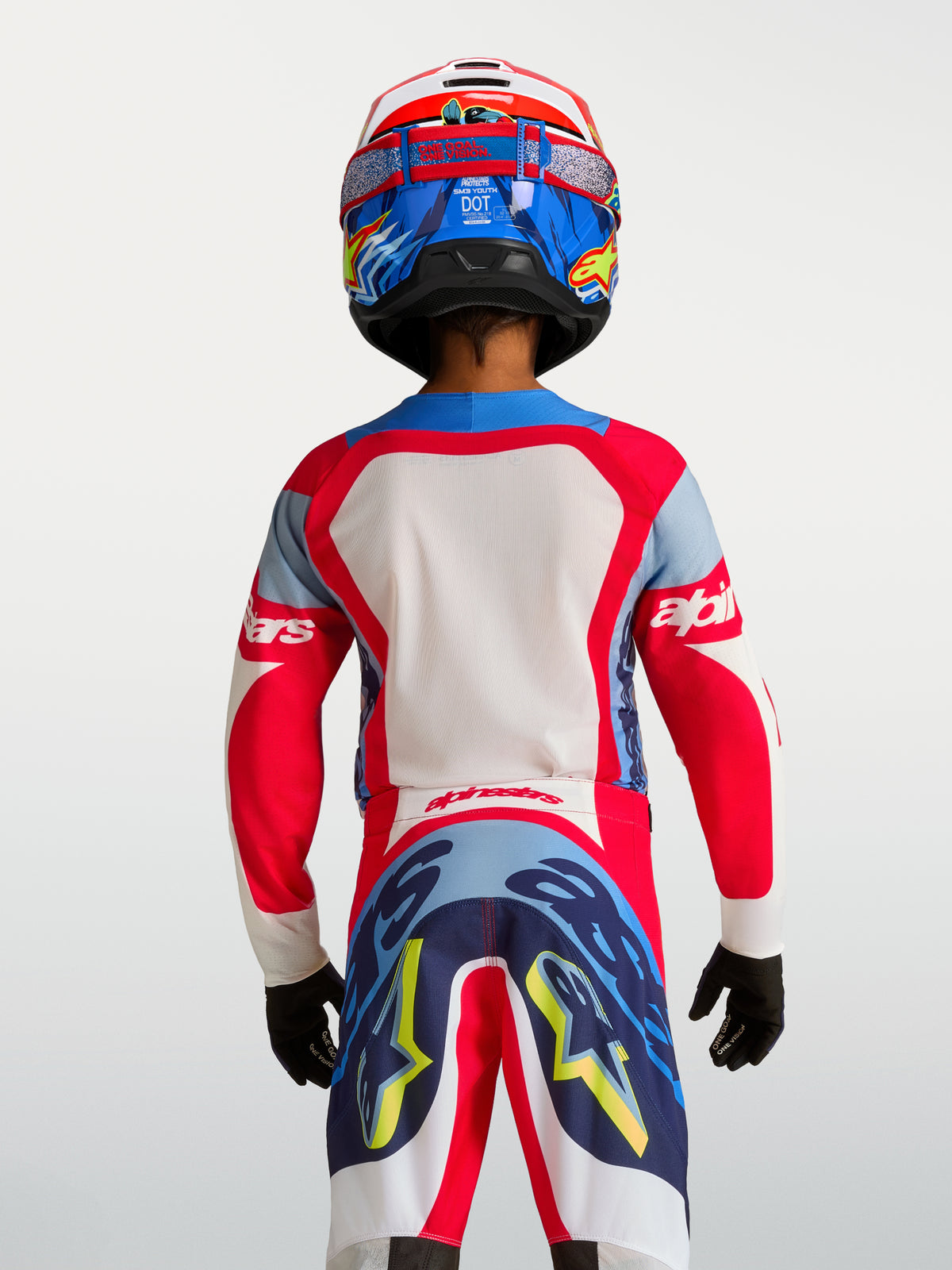 Maillot Supertech Dyna Junior 2027 d'Alpinestars, rouge et bleu marine, vue de dos sur un jeune pilote, maille extensible respirante pour le motocross