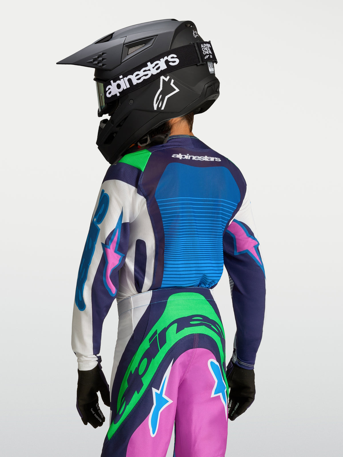 Alpinestars Maillot Supertech Maven Junior, maillot de motocross bleu et vert pour enfant, vue de dos avec casque