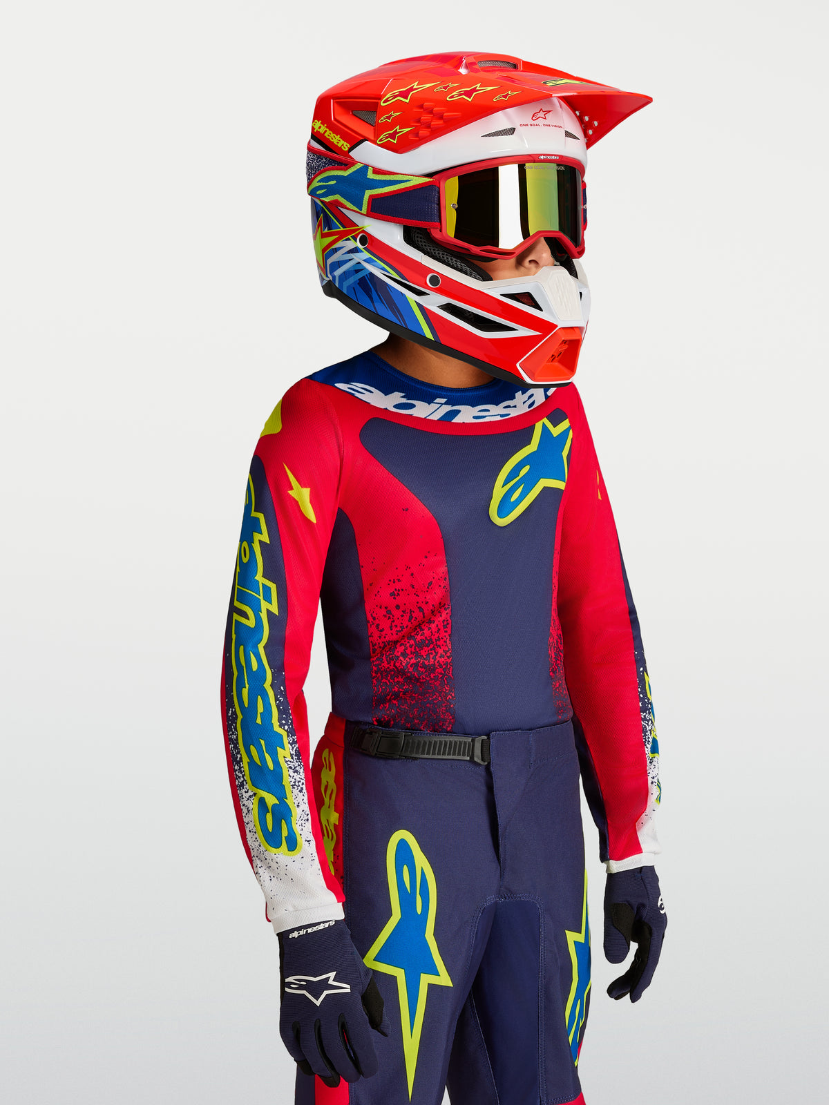 Alpinestars Fluid Jugend-Trikot Drag 2027, Motocross-Ausrüstung in Blau und Rot mit passendem Rennhelm.