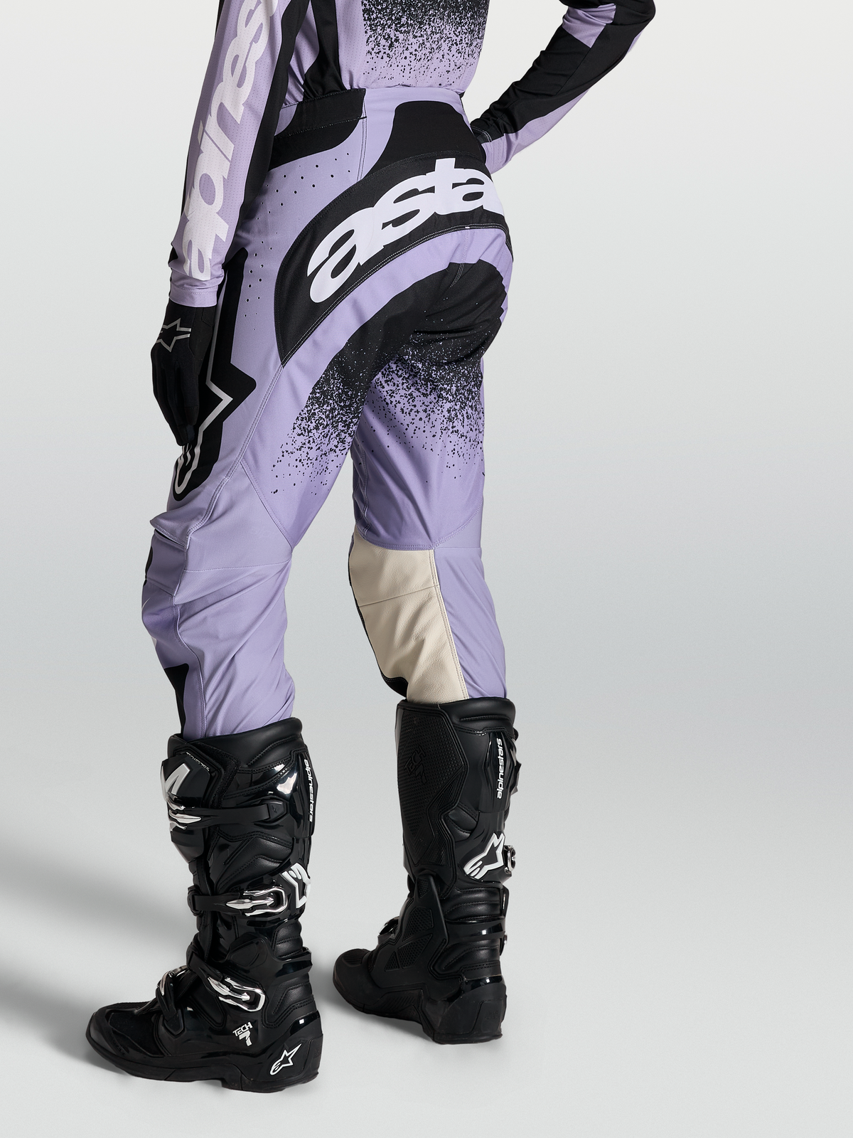 Pantalon Alpinestars Stella Techstar Swan, pantalon de motocross pour femme, violet clair et noir, porté avec des bottes Tech 7 noires, équipement de performance tout-terrain