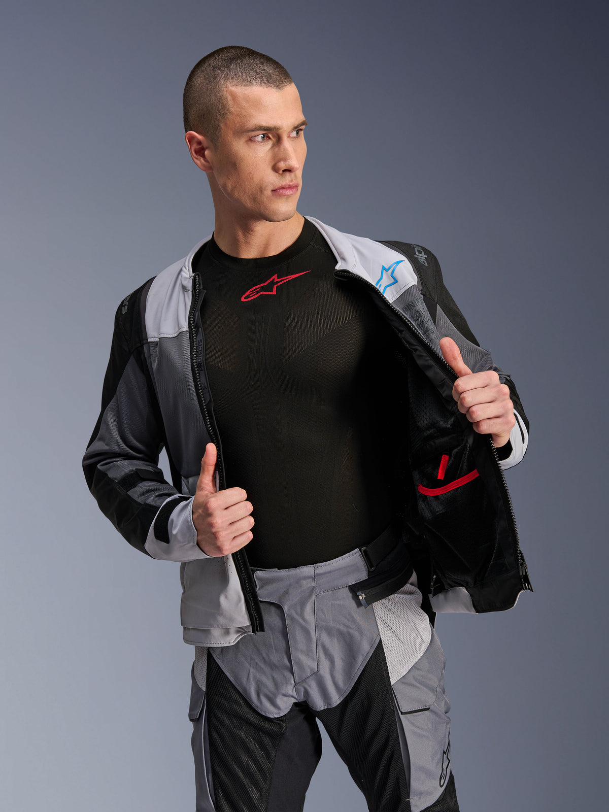 Alpinestars ST-2 Air Jacke, Ice Gray Dark Gray Black, Motorrad-Tourenjacke, offen getragen, um das Mesh-Innenfutter und die Taschen zu zeigen, kombiniert mit passender Hose und schwarzem Base-Layer