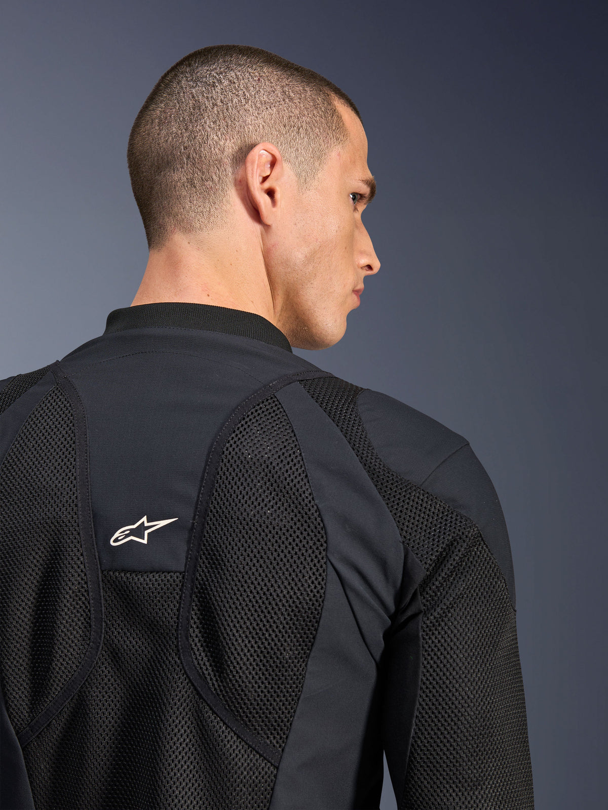 Alpinestars Troop-Air Pro Jacke, Schwarz, Nahaufnahme der Rückseite mit atmungsaktiven Tech-Mesh-Einsätzen und weißem Stern-Logo, hochwertige Motorrad-Protektorenjacke