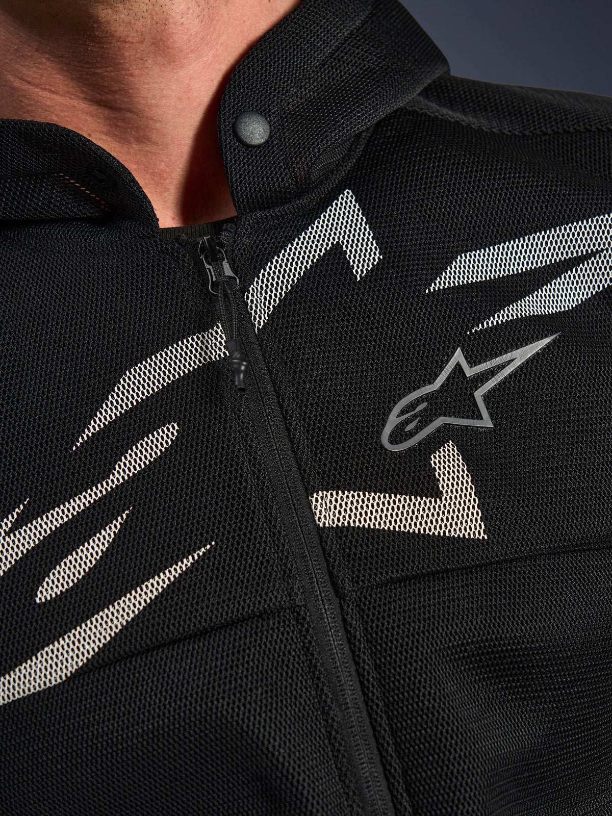 Alpinestars Chrome Superairflow Hoodie, Motorrad-Hoodie, Schwarz mit weißen und grauen Grafiken, Nahaufnahme der Brust mit technischer 3D-Mesh-Konstruktion, Frontreißverschluss und Druckknopfkragen, mit Alpinestars-Logo