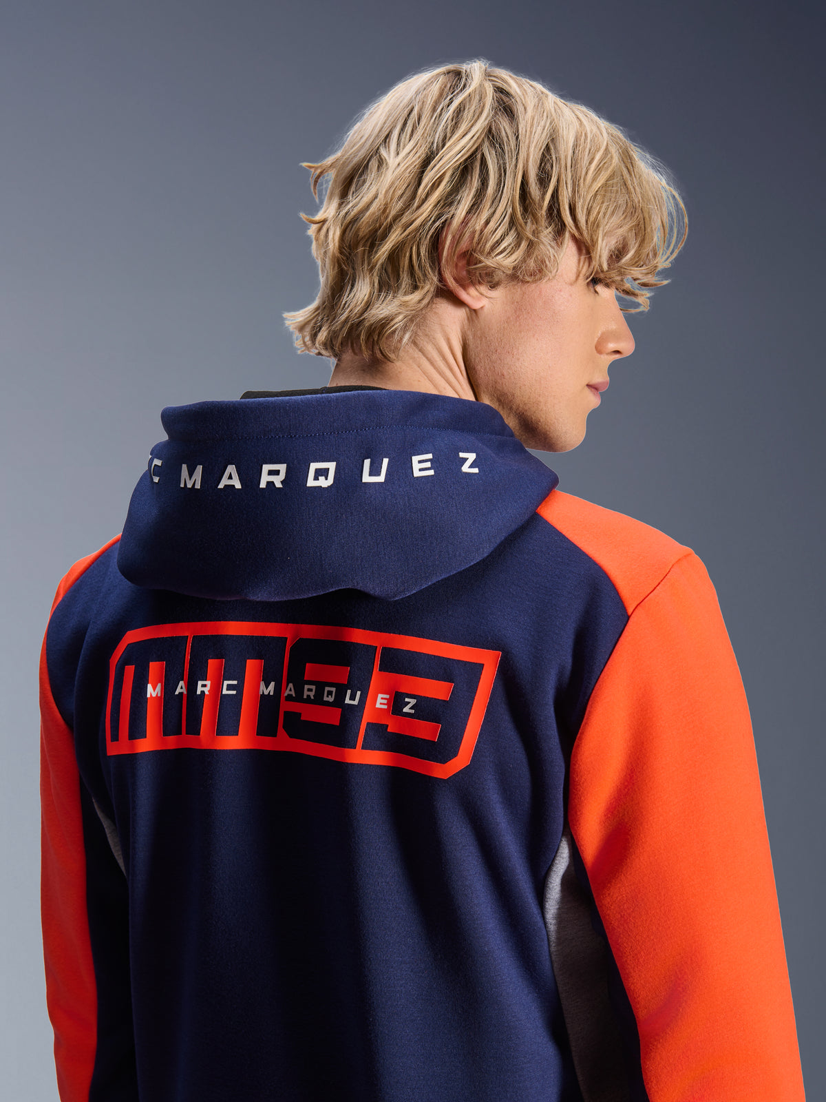 Alpinestars MM93 Chrome V2 Sport Hoodie, donkerblauw met feloranje mouwen, groot rood MM93-logo en Marc Marquez-branding op de rug, witte letters op de capuchon, casual urban motorhoodie.