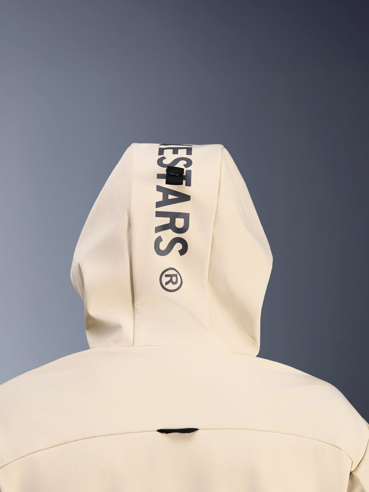 Alpinestars Radium Tech Hoodie in Mastic Aluminum, Nahaufnahme der Kapuze von hinten, vertikaler schwarzer Alpinestars-Schriftzug, Schlaufensystem zur Kapuzenbefestigung, Detail urbaner Motorradbekleidung