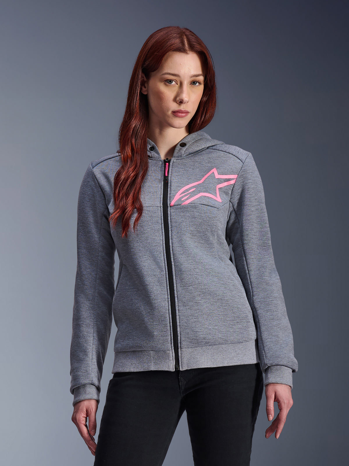 Alpinestars Stella Chrome V2 Sport Hoodie, sweat à capuche de moto pour femme, gris chiné avec logo étoile rose fluo, tissu polaire technique avec poignets et ourlet côtelés, fermeture éclair noire avec tirette rose, style urbain décontracté porté avec un pantalon noir