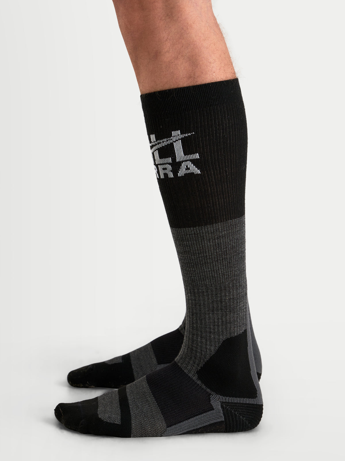 Alpinestars AT-8 Merino sokken, adventure motorsokken in targrijs en zwart, thermische mix van merinowol met geribbelde schacht en versterkte hiel en teen, gedragen op een model
