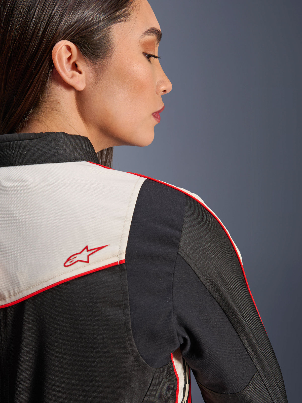 Veste Alpinestars Stella T-Dyno WR en Noir Écru Rouge Vif, gros plan sur l'épaule et le dos, avec empiècements écrus, liseré rouge et logo étoile Alpinestars rouge, équipement de moto textile pour femme