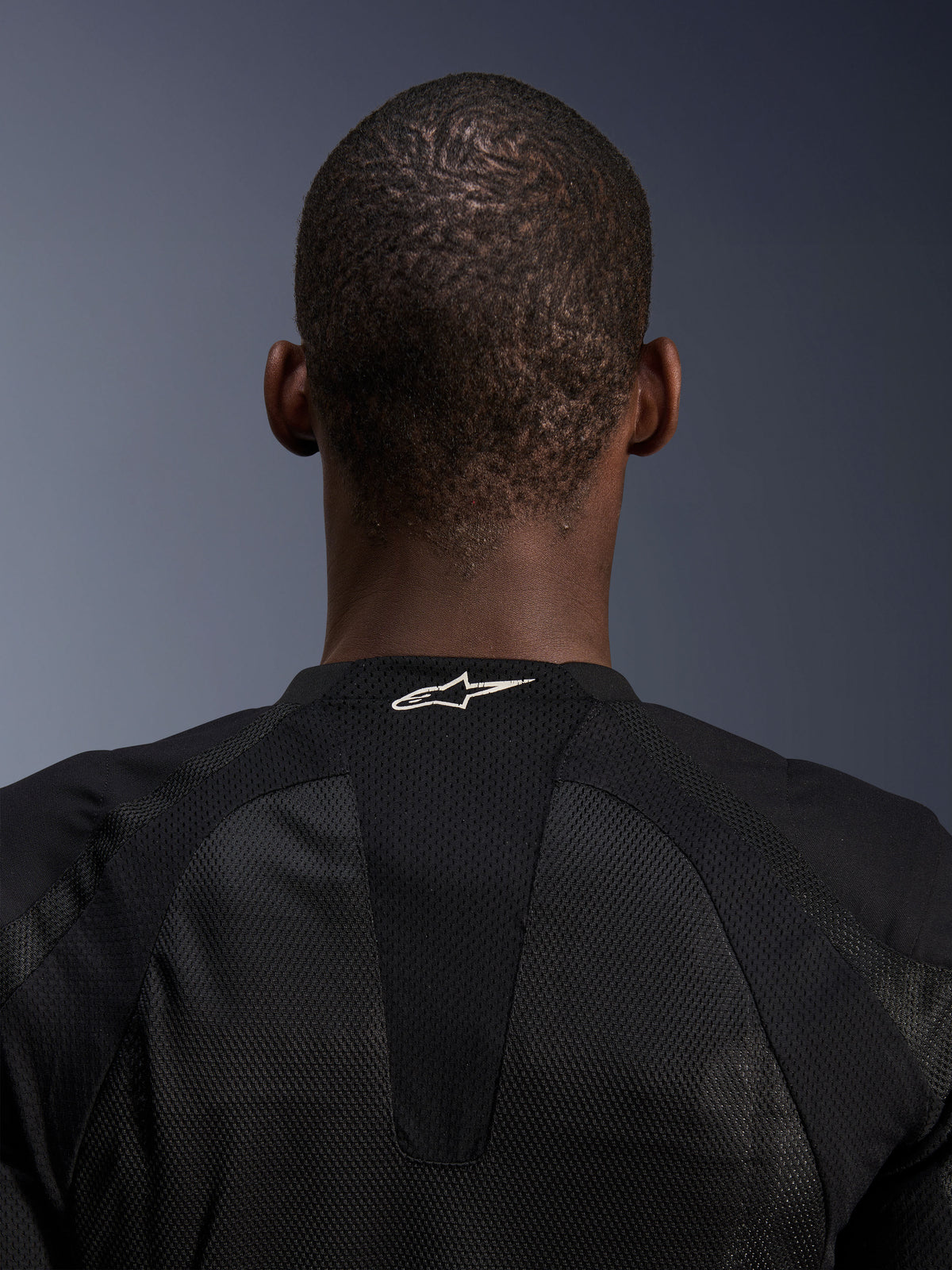 Alpinestars Troop-Air Jacket, black tech mesh motorcycle jacket detail showing white logo on back neck.