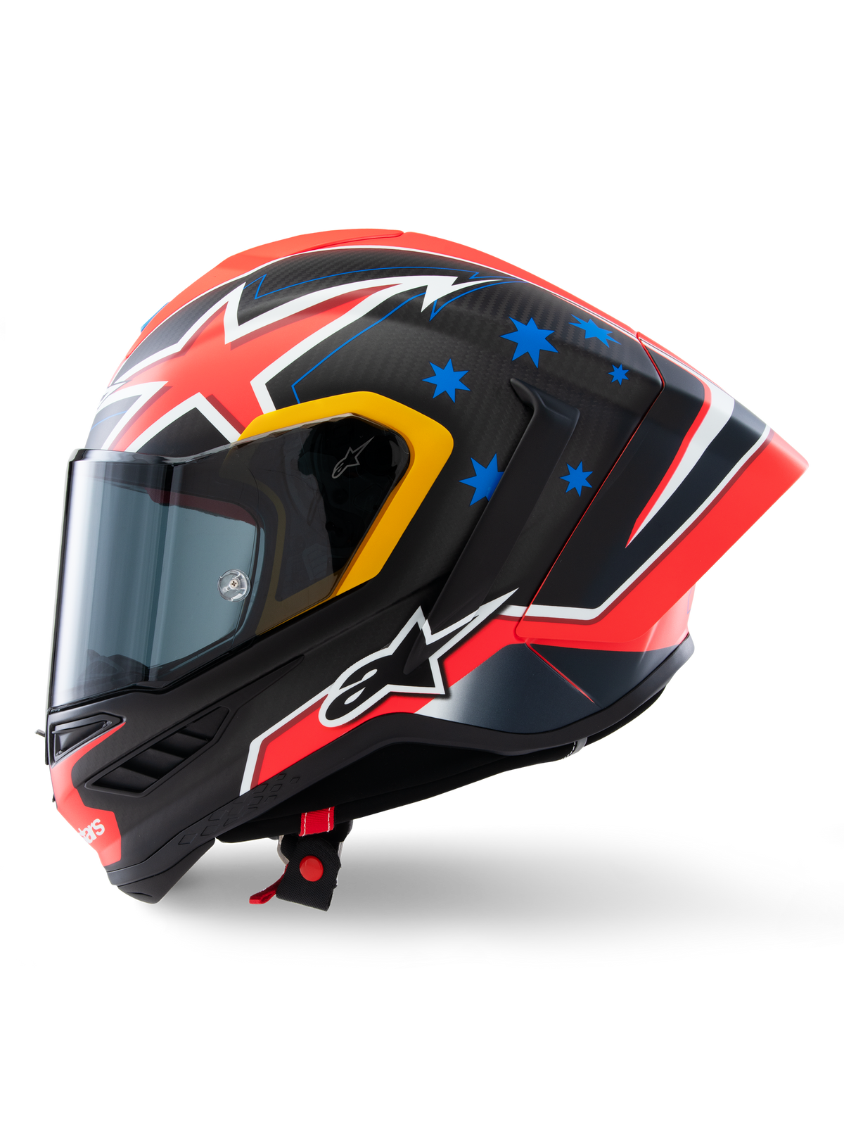 Alpinestars Supertech R10 Miller Limited Edition Helm, Seitenprofil, Carbon Red Matt Finish mit sichtbarem Carbonfasergewebe, rot-weiße Blitzgrafiken, blaue Sterne auf der Rückseite, gelbe Akzente um das Visier, weißes Alpinestars-Logo, Hochleistungs-Rennmotorradhelm