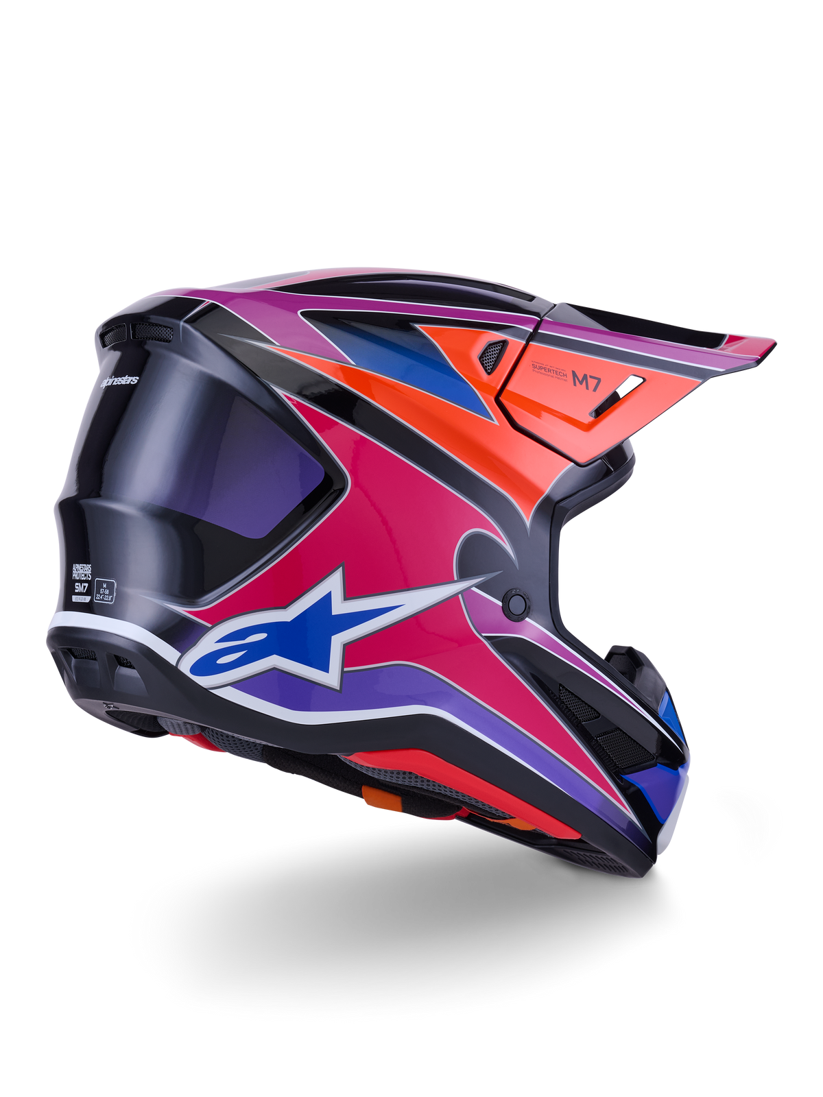Alpinestars S-M7 Fuse Helm, Motocross-Helm, Blau, Lila und Pink glänzend mit orangefarbenen und schwarzen Akzenten, Dreiviertelansicht von hinten zeigt die aerodynamische Schale, das Visier und die Belüftungsöffnungen, professioneller Schutz für den Offroad-Rennsport
