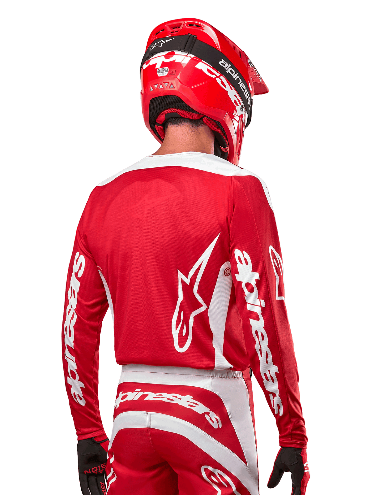 Alpinestars 2024 Fluid Lurv Jersey, motorcross shirt, Mars Red en wit, achteraanzicht met wit Alpinestars-logo op de rug en branding op de mouwen, gecombineerd met een bijpassende rode helm en zwarte handschoenen, professionele off-road race-uitrusting