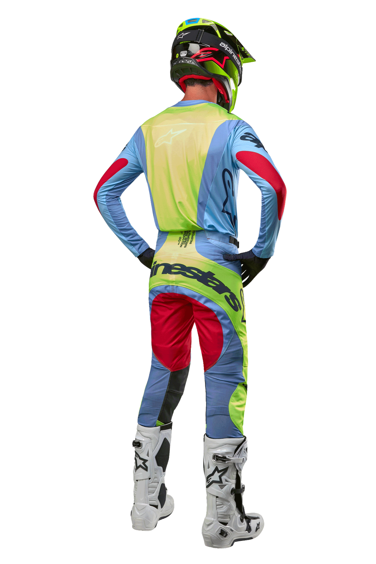 Motocross rider from behind wearing 2024 Techstar Ocuri Pants and matching jersey, Light Blue Yellow Fluo and Red Berry, white and black boots, black helmet with neon accents, coordinated Alpinestars gear for off-road racing
