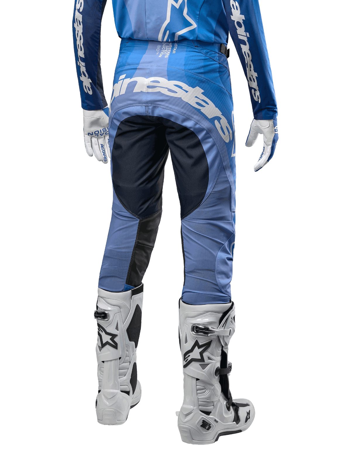 Alpinestars 2024 Techstar Pneuma Pants, pantalon de motocross, bleu marine et bleu clair, vue arrière avec marquage blanc imposant sur l'assise et panneaux noirs renforcés, associé à des bottes de motocross Tech 10 blanches.